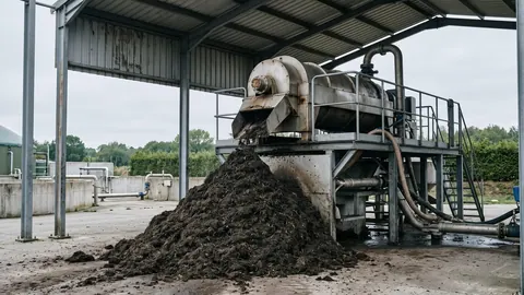 Separator ślimakowy w biogazowni zrzuca stałą frakcję pofermentu na pryzmę pod zadaszeniem.