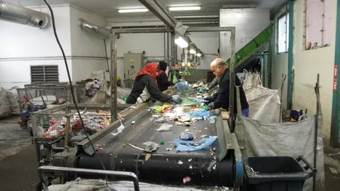 Pracownicy ręcznie sortują tworzywa sztuczne z przenośnika taśmowego w sortowni odpadów w Ołomuńcu w Czechach.
