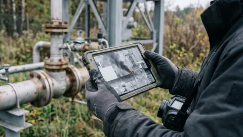 Technik w rękawicach dokumentuje wyciek na tablecie: na ekranie obraz OGI z zaznaczonym punktem nieszczelności.
