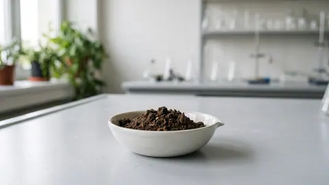 Porcelanowa parownica z ciemnobrązowym, lekko zbrylonym proszkiem ligniny – stałą pozostałością po hydrolizie drewna.